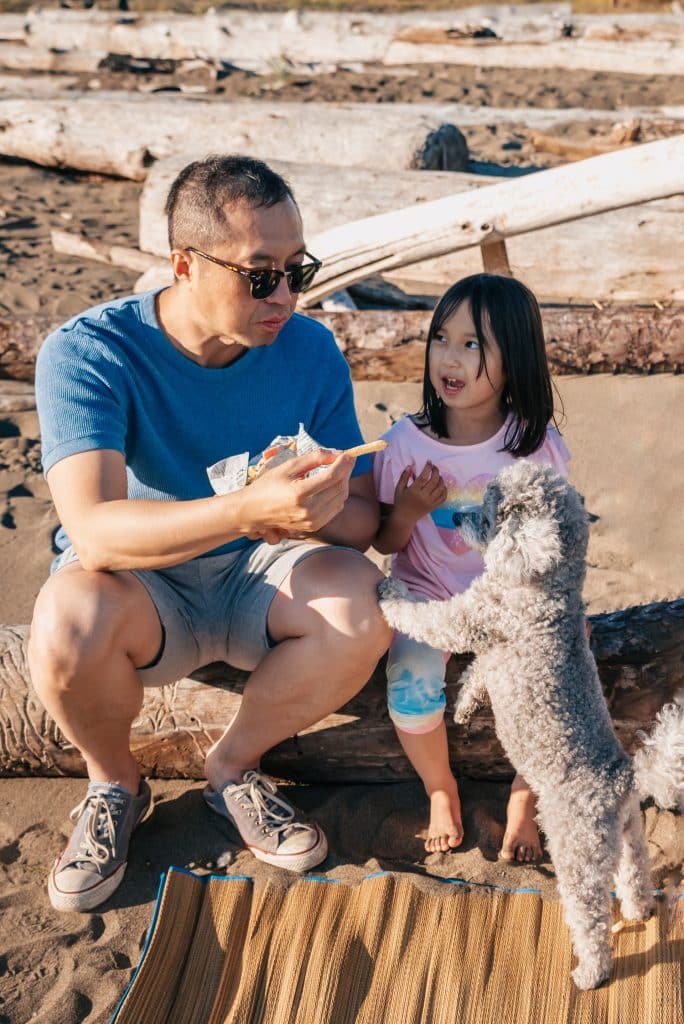 Dad and daughter feeding dog